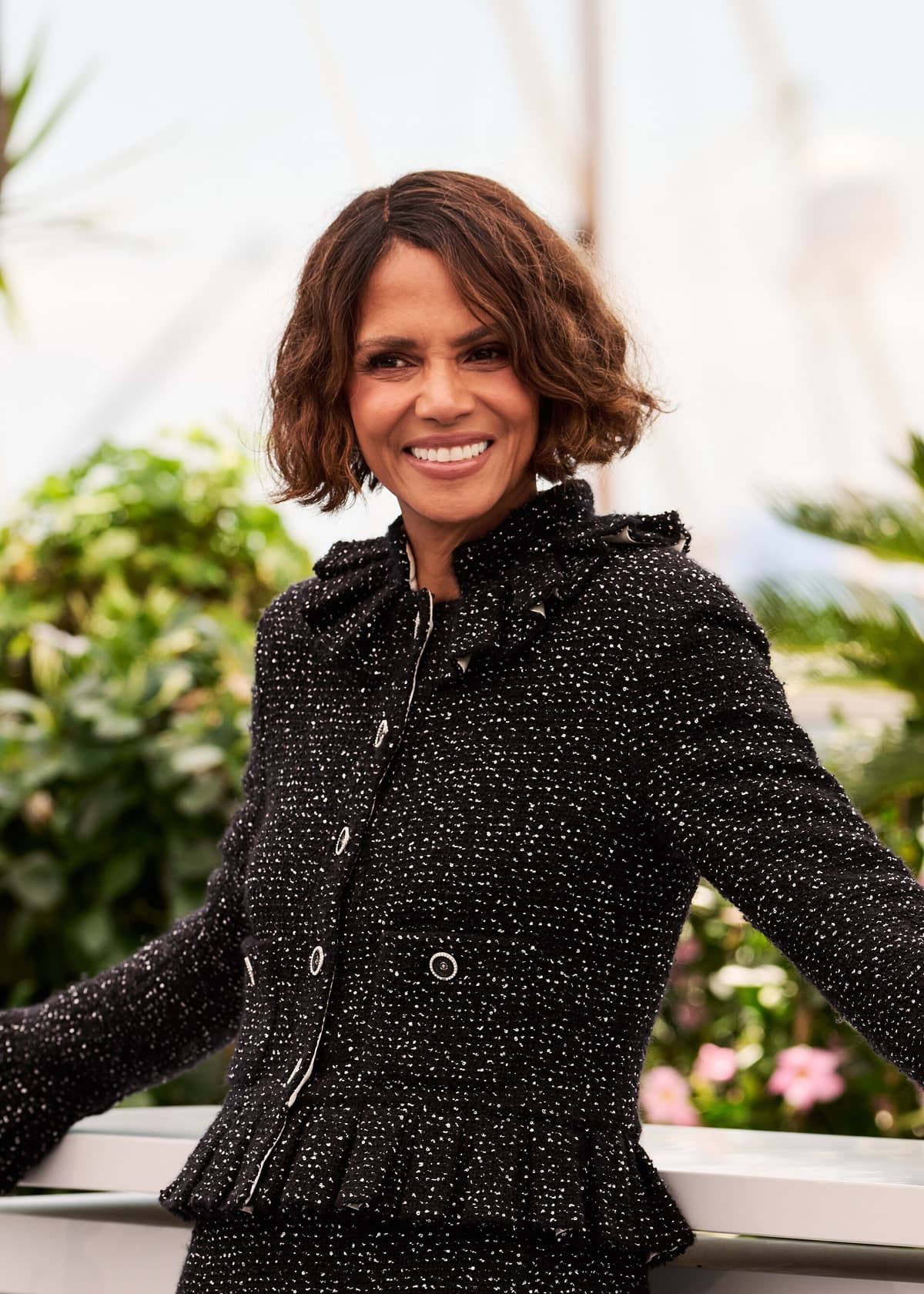 Cannes frontal — luminous skin, high cheekbones, soft smile under festival key.