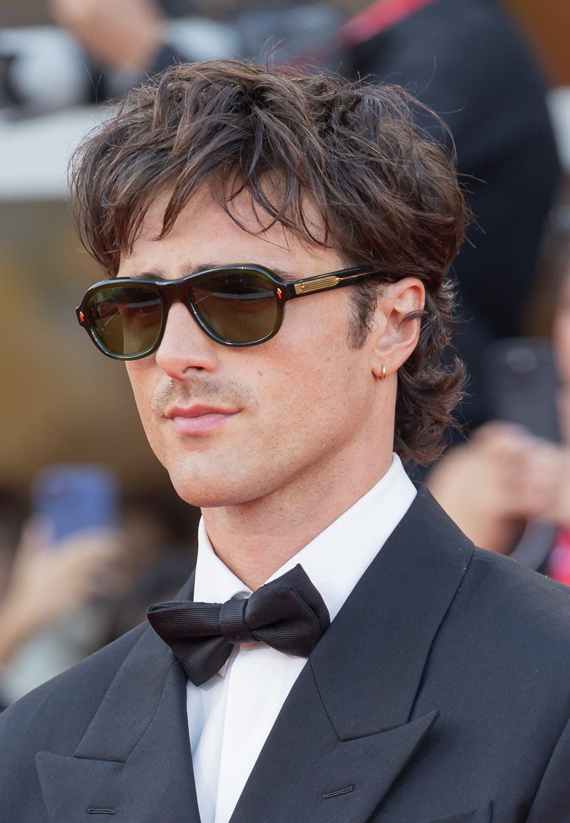 Tux + sunglasses era — study mandibular silhouette when eyes are occluded.