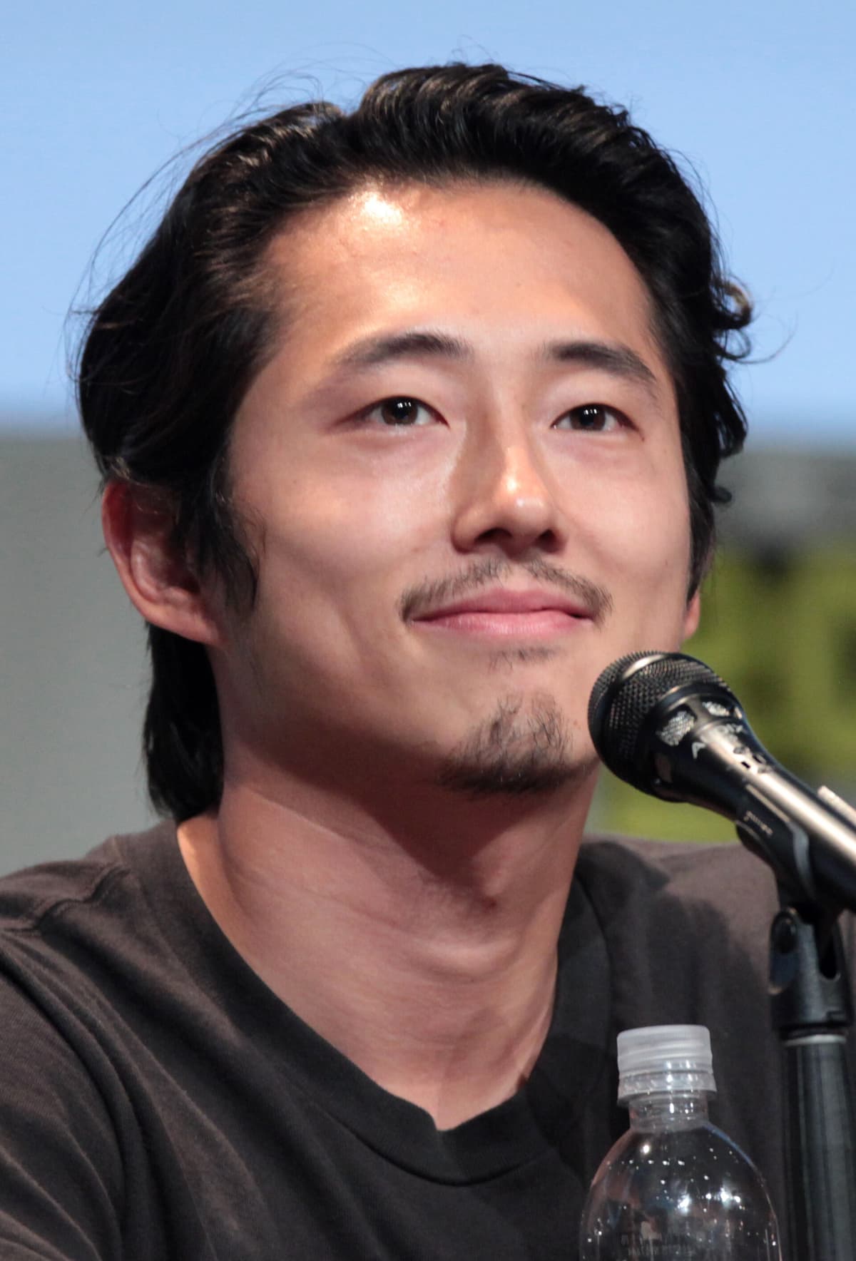 Comic-Con cropped still — warm eyes and soft-smile leading-man read.